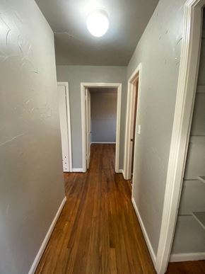 Tulsa house for rent - a hallway with a hard wood floor and a closet