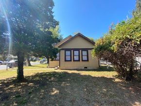 Tulsa house for rent - a small tan house with a yard and a tree