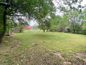 Tulsa house for rent - a grassy field with trees and a fence