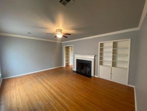 Tulsa house for rent - a living room with a fireplace and a ceiling fan