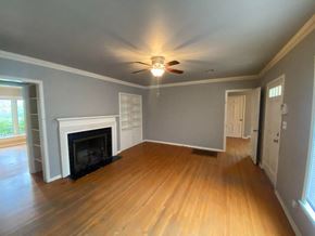 Tulsa house for rent - a living room with a fireplace and a ceiling fan