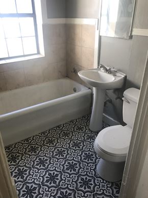 Tulsa house for rent - A white toilet sits in a bathroom with a blue and white floor.