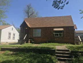 Tulsa house for rent - A small house with a brown roof and a white house in the background.
