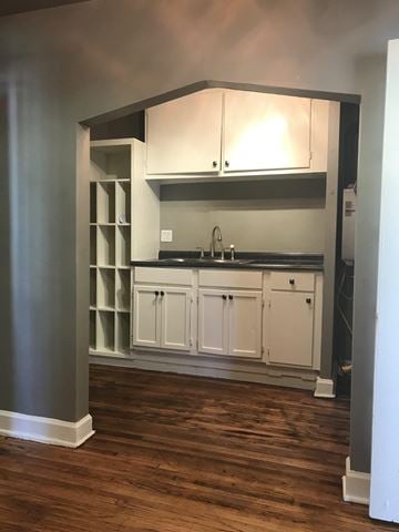 Tulsa house for rent - A kitchen with white cabinets and a dark countertop.