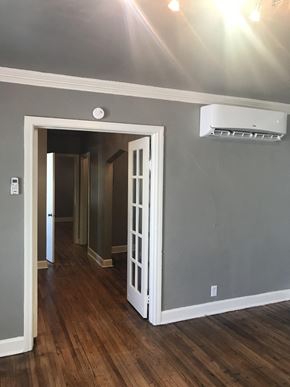 Tulsa house for rent - A room with a white door and a wall-mounted air conditioner.