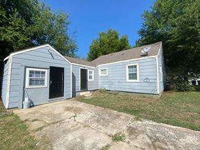 Tulsa house for rent - a blue house with a yard and a driveway