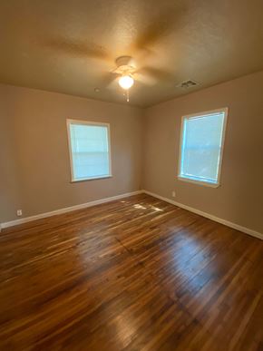 Tulsa house for rent - a empty room with a hard wood floor and two windows