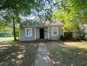 Tulsa house for rent - a small white house with a sidewalk and some trees
