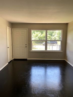 Tulsa house for rent - an empty room with a large window and a door