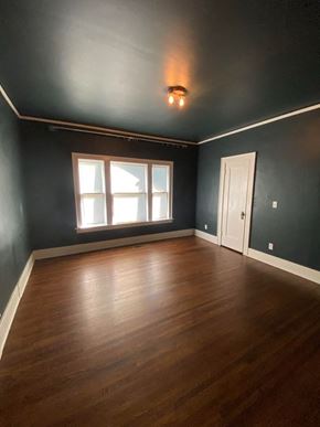Tulsa house for rent - an empty room with a window and wooden floors