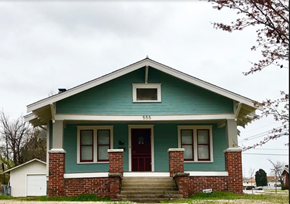 Tulsa house for rent - the front of a green house with a red door