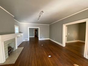 Tulsa house for rent - a living room with a fireplace and wooden floors