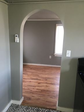 Tulsa house for rent - A room with a wooden floor and a white door.