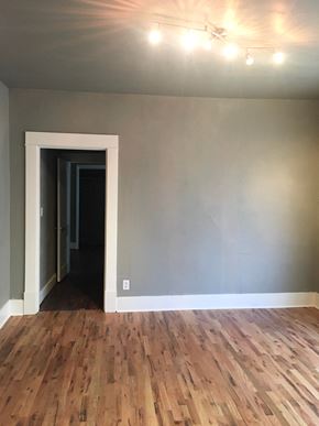 Tulsa house for rent - a living room with gray walls and wooden floors