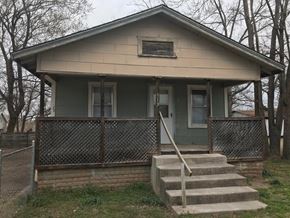 Tulsa house for rent - a small green house with steps and a fence