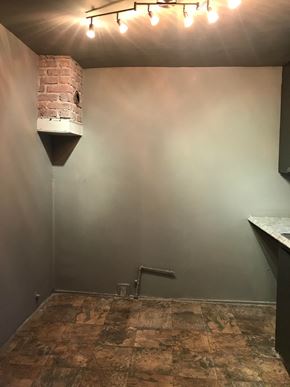 Tulsa house for rent - a room with white walls and a red brick wall and a pipe in the corner