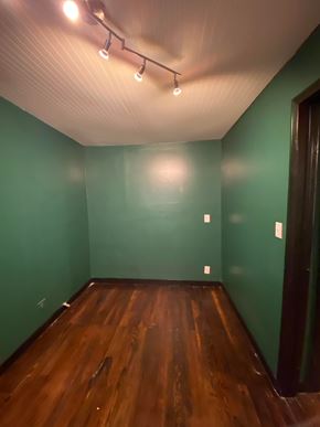 Tulsa house for rent - A room with wooden floors and green walls.