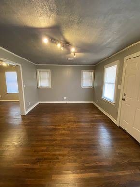 Tulsa house for rent - A room with wooden floors and a white door.