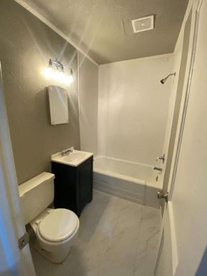 Tulsa house for rent - A small bathroom with a toilet, sink, and shower.