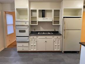 Tulsa house for rent - an empty kitchen with white appliances and white cabinets