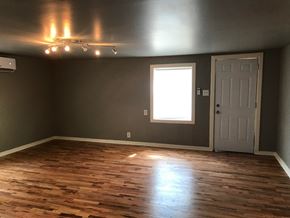 Tulsa house for rent - a gray room with wooden floors and a window and a door