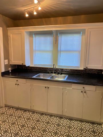 Tulsa house for rent - a kitchen with white cabinets and a sink