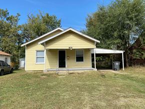 Tulsa house for rent - a small yellow house with a yard and trees