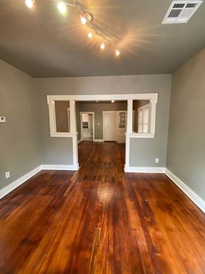 Tulsa house for rent - an empty living room with wooden floors and gray walls