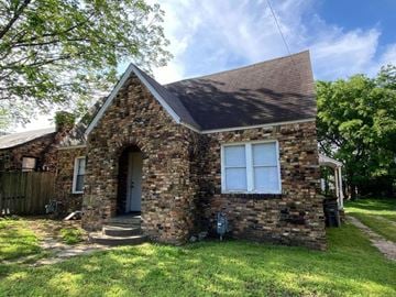 Tulsa house for rent - a small brick house with a front yard and grass