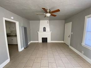 Tulsa house for rent - a living room with a ceiling fan and a fireplace