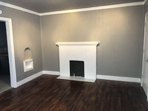 Tulsa house for rent - a living room with a fireplace and wooden floors