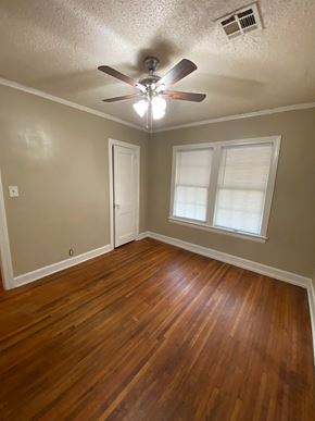 Tulsa house for rent - A room with a ceiling fan and wooden flooring.