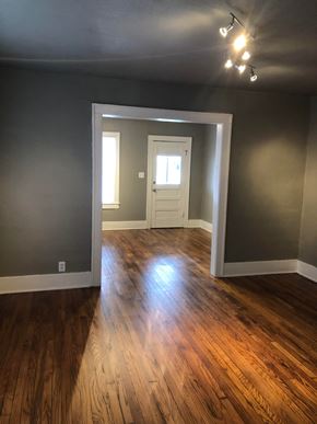 Tulsa house for rent - an empty living room with a hard wood floor and gray walls