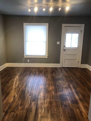 Tulsa house for rent - a living room with a hard wood floor and a door