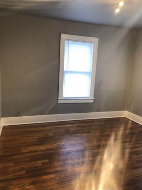 Tulsa house for rent - an empty room with a window and wooden floors