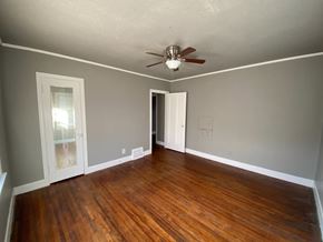 Tulsa house for rent - A room with a ceiling fan and wood flooring.