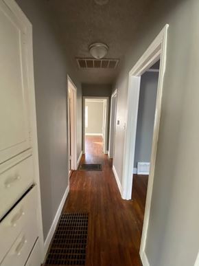 Tulsa house for rent - A long hallway with a door on the right and a white door on the left.