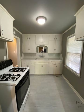 Tulsa house for rent - A kitchen with white cabinets and a black stove top oven.