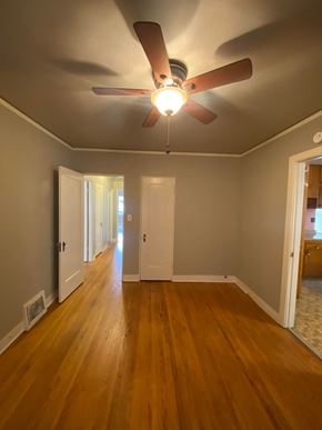 Tulsa house for rent - a living room with wood floors and a ceiling fan