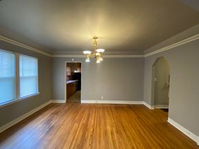 Tulsa house for rent - an empty living room with wood flooring and a chandelier