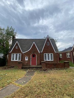 Tulsa house for rent - a brick house with a red door and a cloudy sky