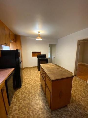 Tulsa house for rent - a kitchen and living room with a counter and a refrigerator