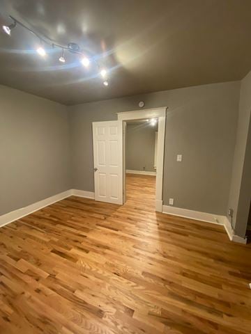 Tulsa house for rent - a living room with wooden floors and grey walls and a white door