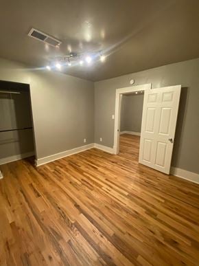 Tulsa house for rent - a living room with wooden floors and a white door