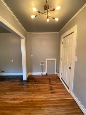 Tulsa house for rent - a living room with wood floors and a white door and a chandelier