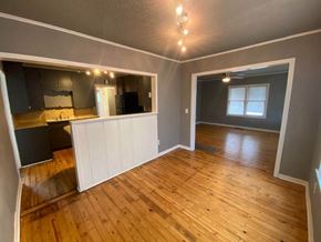 Tulsa house for rent - A room with wooden flooring and a large mirror on the wall.