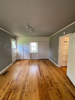 Tulsa house for rent - A room with wooden floors and white walls.
