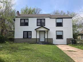 Tulsa house for rent - a white house with black windows and a sidewalk