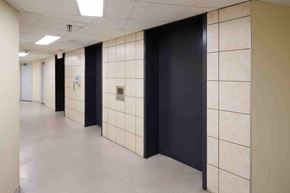 Etobicoke apartment for rent - A hallway with black doors and white walls.