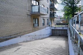 Toronto apartment for rent - A view of a courtyard between two buildings with a metal railing on the right side.